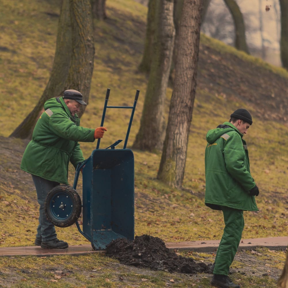 Two grounds crew in uniform working together during the season
